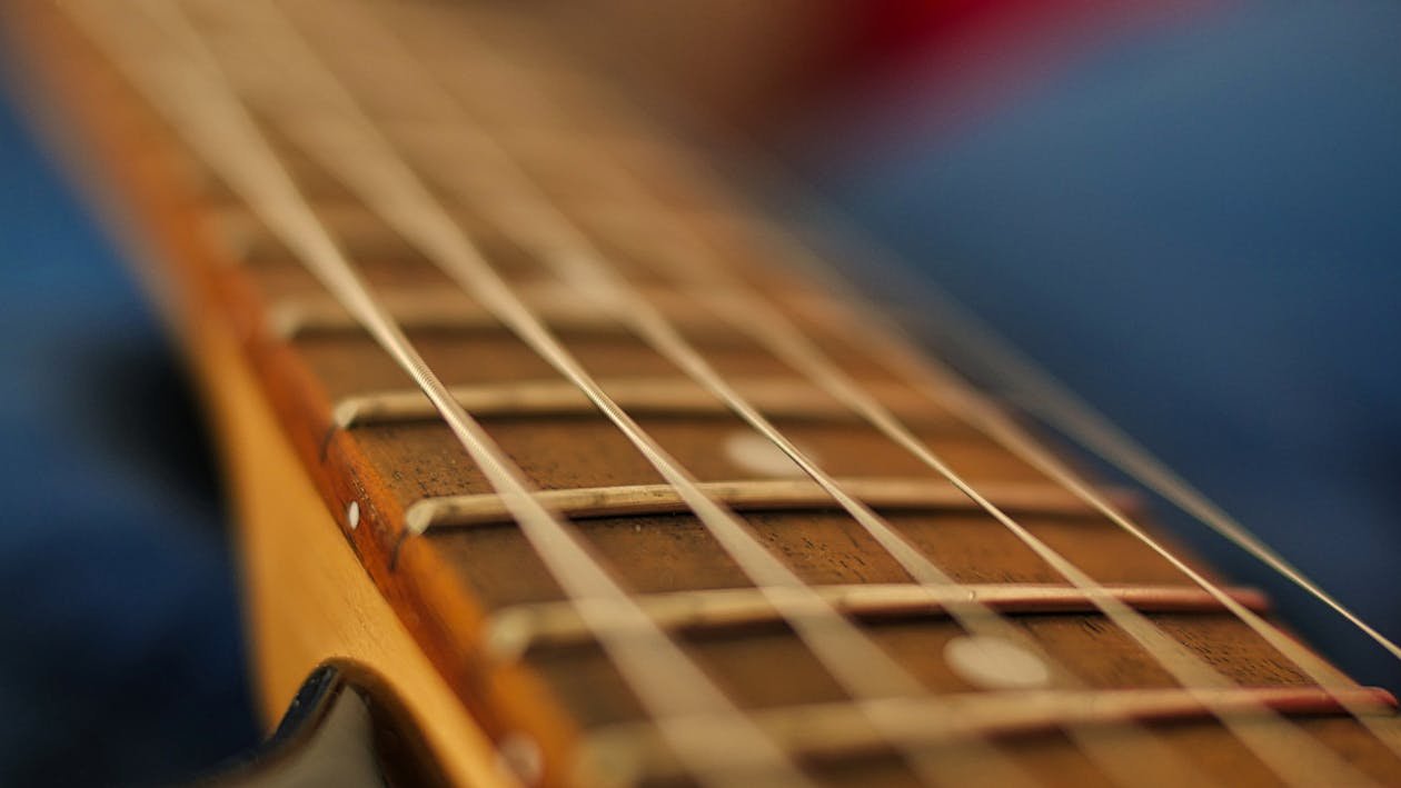 Electric guitar fretboard and strings close-up with artistic bokeh